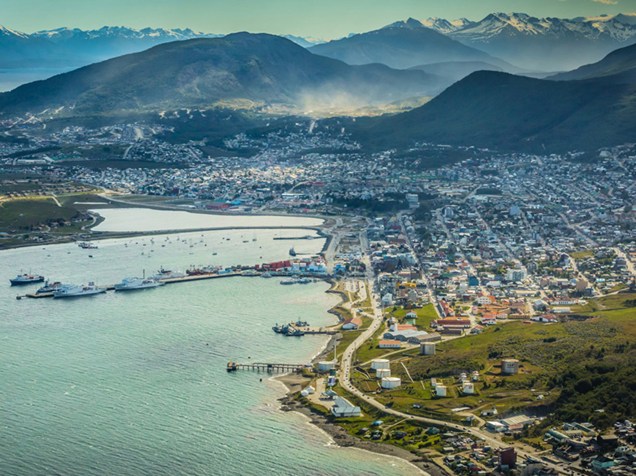 Vista aérea panorâmica da cidade e zona portuária do Ushuaia, com a Cordilheira dos Andes ao fundo
