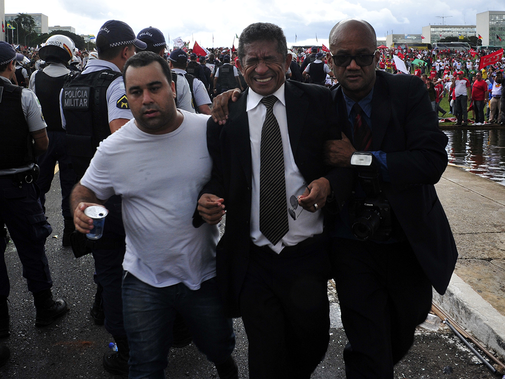 O deputado Vicentinho (PT-SP) é retirado de de confusão durante protesto de Centrais Sindicais no gramado do Congresso