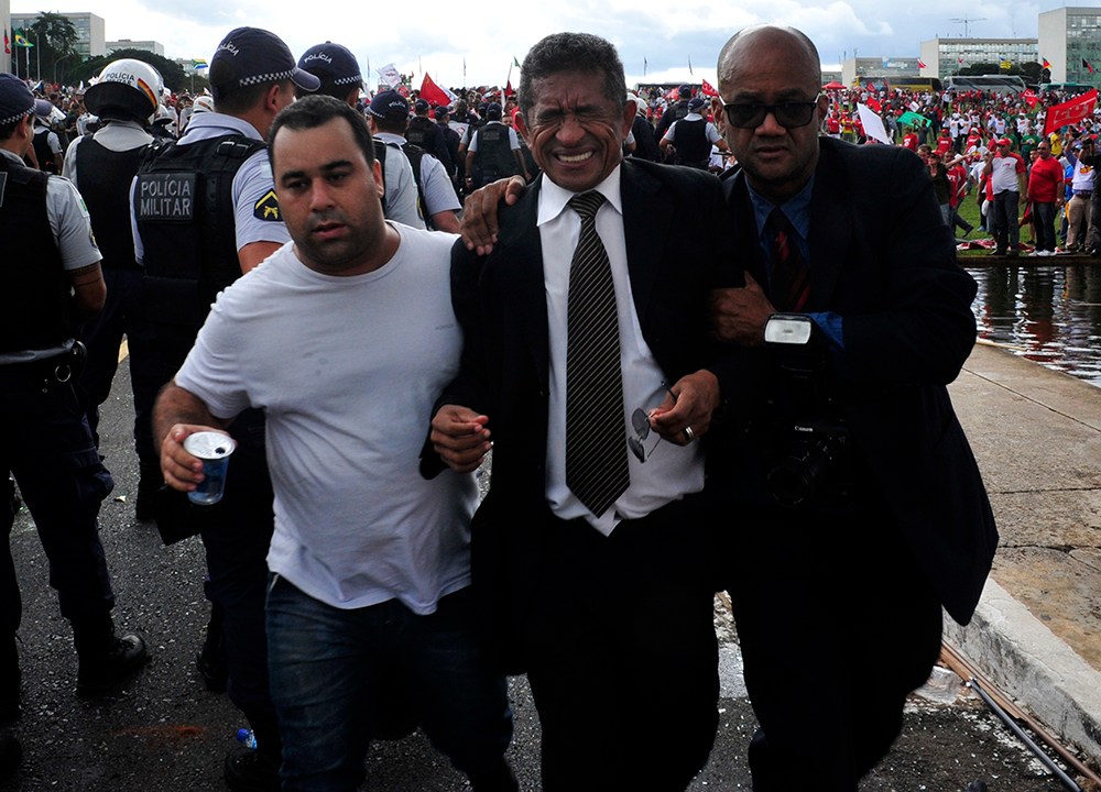O deputado Vicentinho (PT-SP) é retirado de de confusão durante protesto de Centrais Sindicais no gramado do Congresso