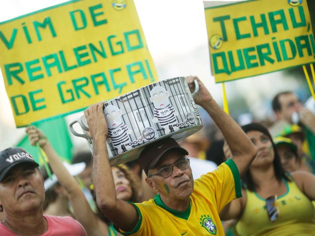 Manifestantes levantam cartaz em protesto a favor do Impeachment, em Copacabana, no Rio de Janeiro, enquanto aguardam pelo início das votações na Câmara dos Deputados - 17/04/2016