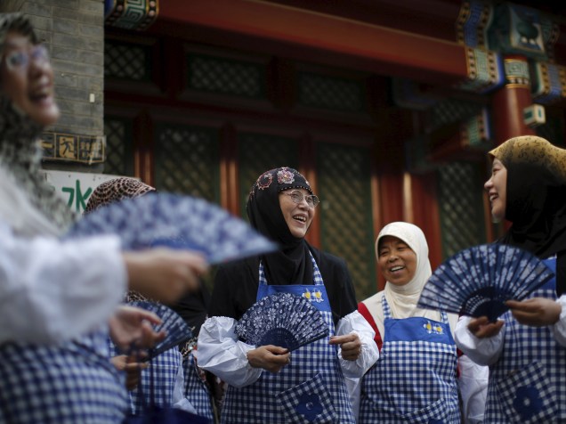 Muçulmanas conversam enquanto preparam comida para o desjejum com outros devotos no primeiro dia do mês sagrado do Ramadan, em Pequim, China