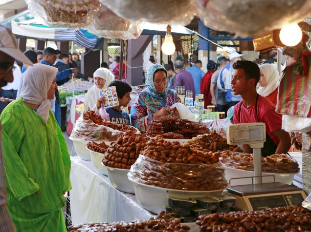 Comerciante vende bolos tradicionais feitos de mell e iguarias para clientes durante o primeiro dia do Ramadã, Oujda, Marrocos