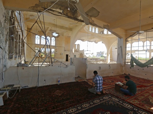 Homem reza em uma mesquita danificada no vilarejo Qmenas, Síria, durante o mês sagrado do Ramadã