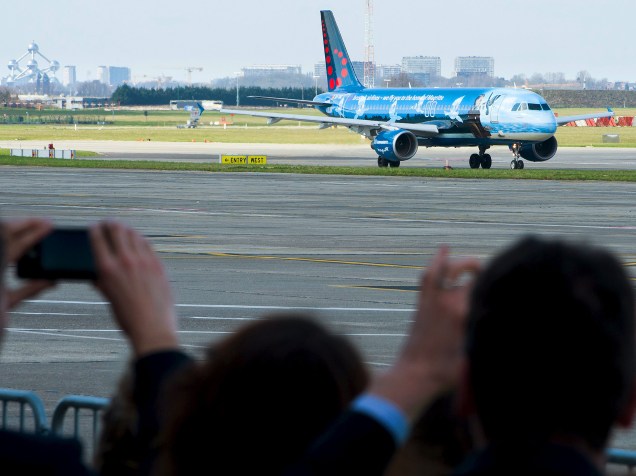 Passageiros fotografam primeiro avião decolando do aeroporto de Zaventem, em sua reabertura neste domingo (03), na capital da Bélgica, Bruxelas, 12 dias após os atentados que deixaram dezenas de mortos