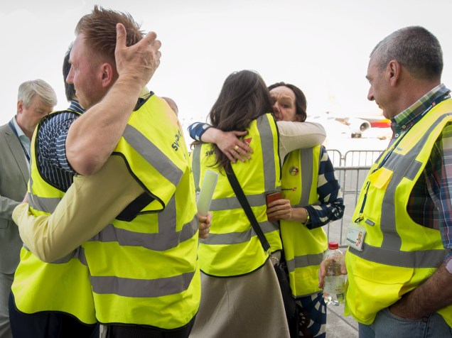 Funcionários do aeroporto de Zaventem, em Bruxelas, se abraçam após a reabertura do local neste domingo (03), 12 dias após os atentados que deixaram dezenas de mortos