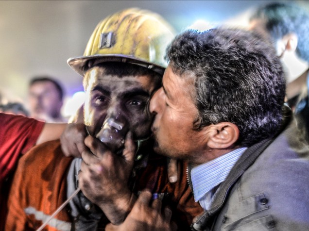 Pai beija filho resgatado de uma mina de carvão em Manisa, na Turquia. Mais de 200 mineiros foram mortos após desabamento na cidade