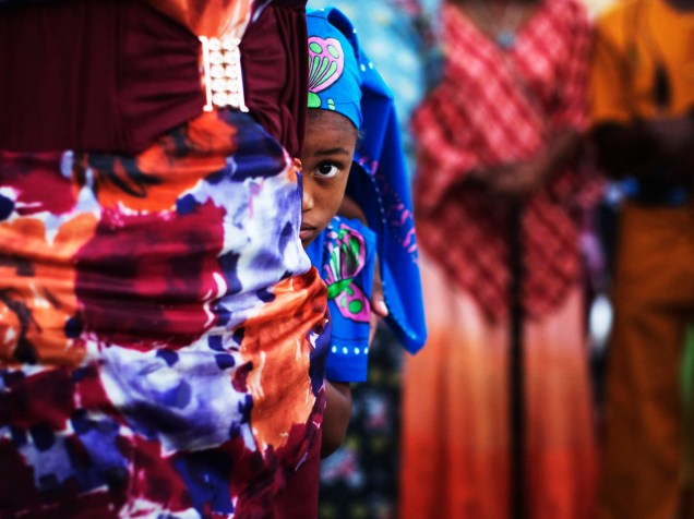 Menina de uma comunidade africana popularmente conhecida como The Black Hebreus, se esconde durante uma celebração na cidade de Dimona, em Israel