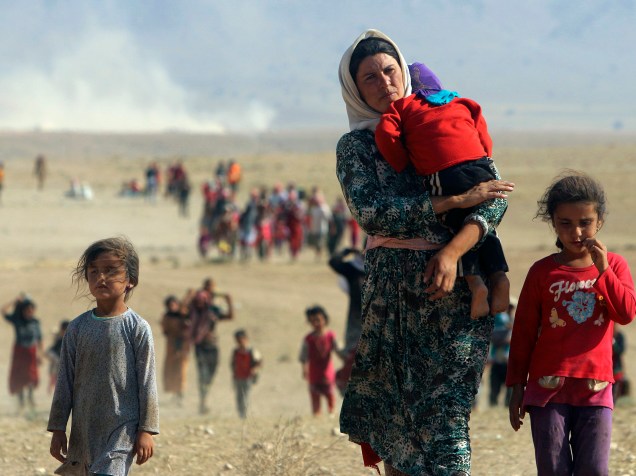 Integrantes da minoria yazidi percorrem dezenas de quilômetros a pé pelo deserto rumo à Síria, depois de escaparem de região cercada pelo Estado Islâmico no Iraque