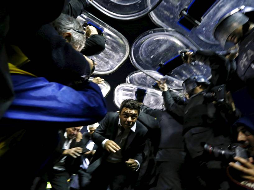 Marcelo Gallardo, técnico do River Plate, é protegido por policiais após a suspensão da partida