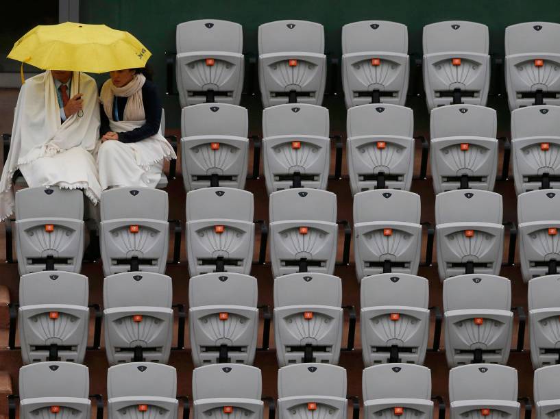 Duas mulheres se protegem da chuva que atingiu a cidade de Paris durante o evento de Roland Garros, na França