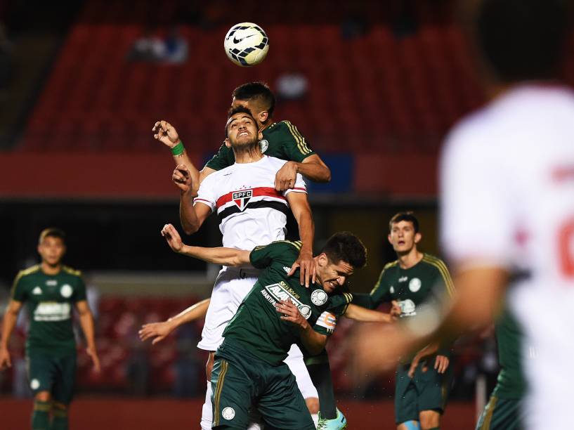 Disputa de bola aérea durante clássico entre Palmeiras e São Paulo. O jogo acontece no Morumbi, em São Paulo/SP