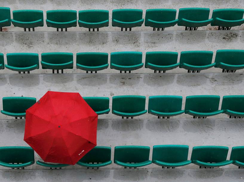 Público se protege da chuva em partida interrompida entre a russa Ekaterina Makarova e a sérvia Ana Ivanovic