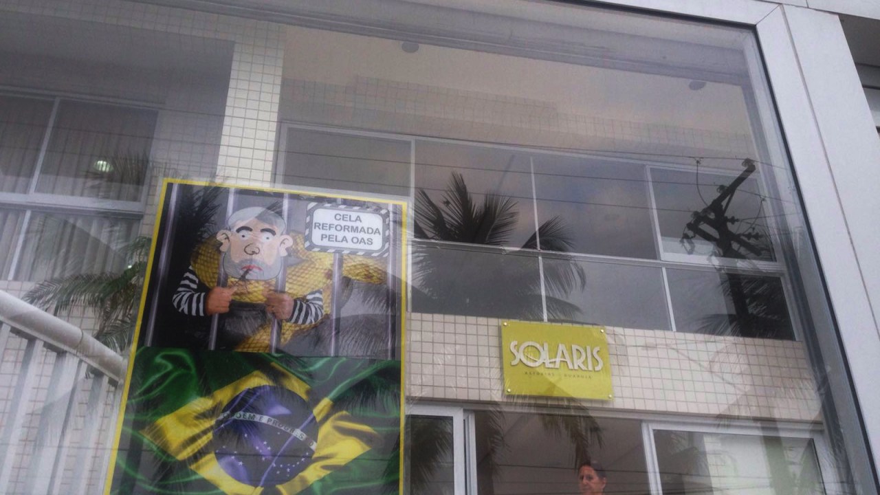 Cartazes de protesto, são colados em frente ao Edifício Solaris, no Guarujá (SP), onde se localiza o triplex pertencente ao ex-presidente Lula, neste domingo (13)