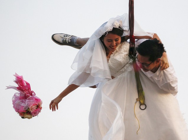 Noivos chegam de rapel à cerimônia de casamento, em Prachinburi, na Tailândia para celebrar o dia de Valentines Day, Dia de São Valentim