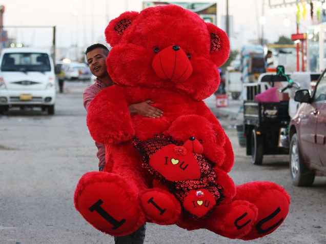 Iraquiano carrega um presente do dia dos Namorados no dia de Valentines Day, Dia de São Valentim, na cidade de Basra