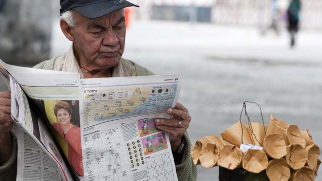 Ambulante lê jornal no dia seguinte às eleições nas ruas do Rio de Janeiro