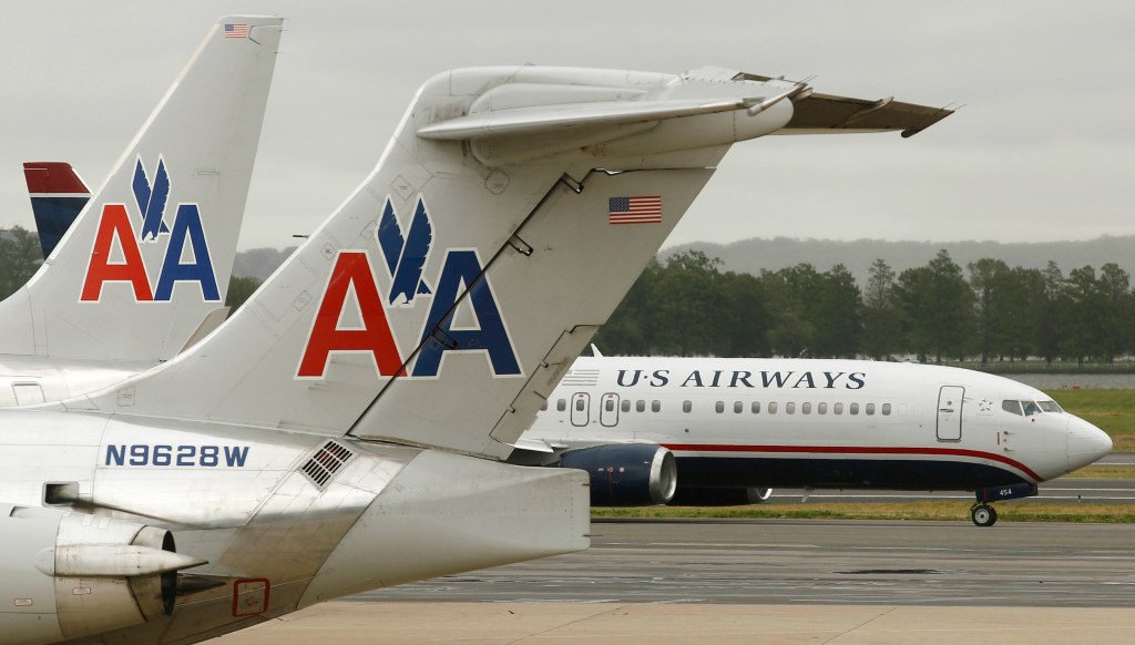 A US Airways plane and an American Airlines plane pass each other at Ronald Reagan National Airport in Arlington County, Virginia, in this file photo taken April 23, 2012. The unsecured creditors committee of bankrupt American Airlines parent AMR Corp has approved an $11 billion merger agreement with US Airways Group Inc, people familiar with the matter said on Wednesday. REUTERS/Kevin Lamarque/Files (UNITED STATES - Tags: TRANSPORT BUSINESS)
