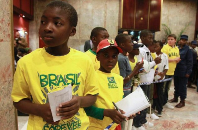 Crianças do Zimbábue aguardam a chegada da seleção brasileira para pegar autógrafos.