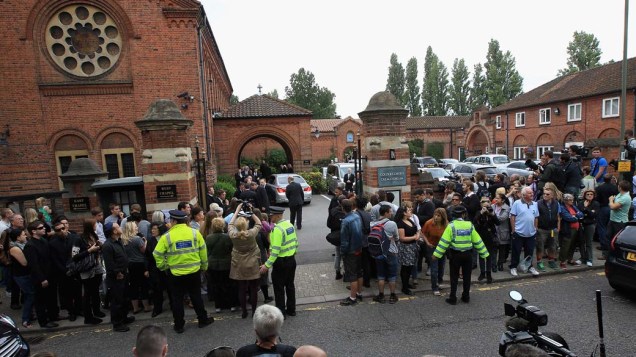 Fãs e imprensa se reúnem ao lado de fora do crematório Golders Green, em Londres