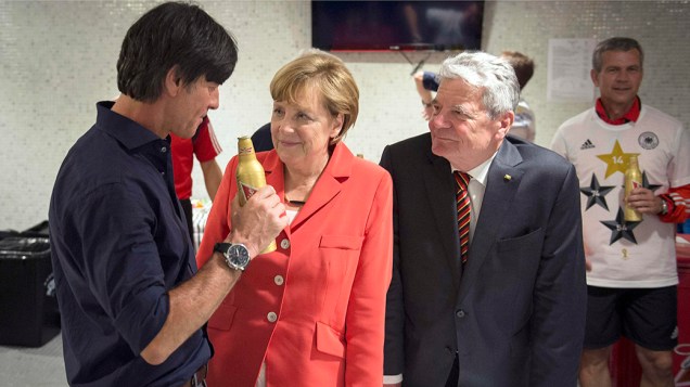 O técnico da Alemanha, Joachim Loew, comemora com a chanceler alemã, Angela Merkel, o título da Copa do Mundo de Futebol de 2014, no estádio do Maracanã, no Rio de Janeiro