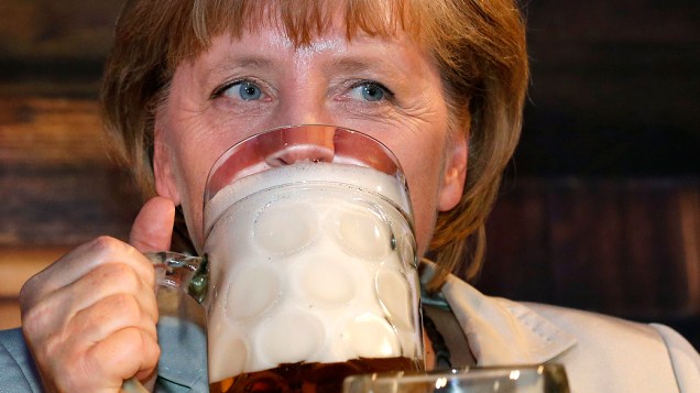 Chanceler alemã, Angela Merkel, bebe um canecão de cerveja durante a abertura da Oktoberfest em Berlim, na Alemanha