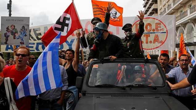 Fantasiados como nazistas, manifestantes protestam em carro aberto na praça Syntagma, em Atenas, durante visita da chanceler alemã, Angela Merkel, à Grécia