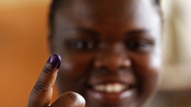Angolana mostra seu dedo sujo de tinta para reprodução de digital após registrar seu voto em um posto da capital Luanda
