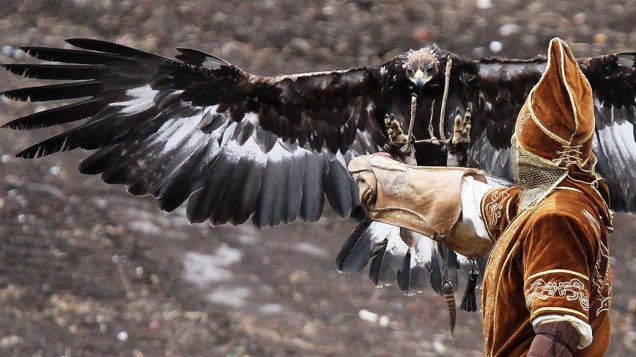 Adestrador exibe sua águia dourada durante festival na cidade de Ust-Kamenogorsk, Cazaquistão