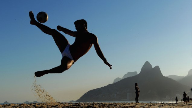 Homem jogando futebol na praia de Ipanema