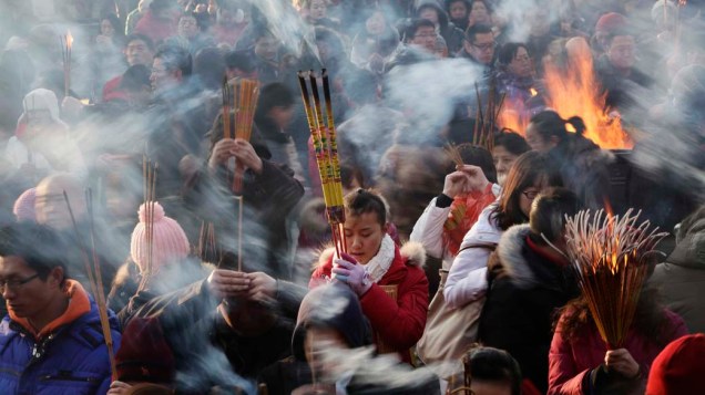 Fiéis queimam incenso enquanto rezam durante o primeiro dia do Ano Novo, China