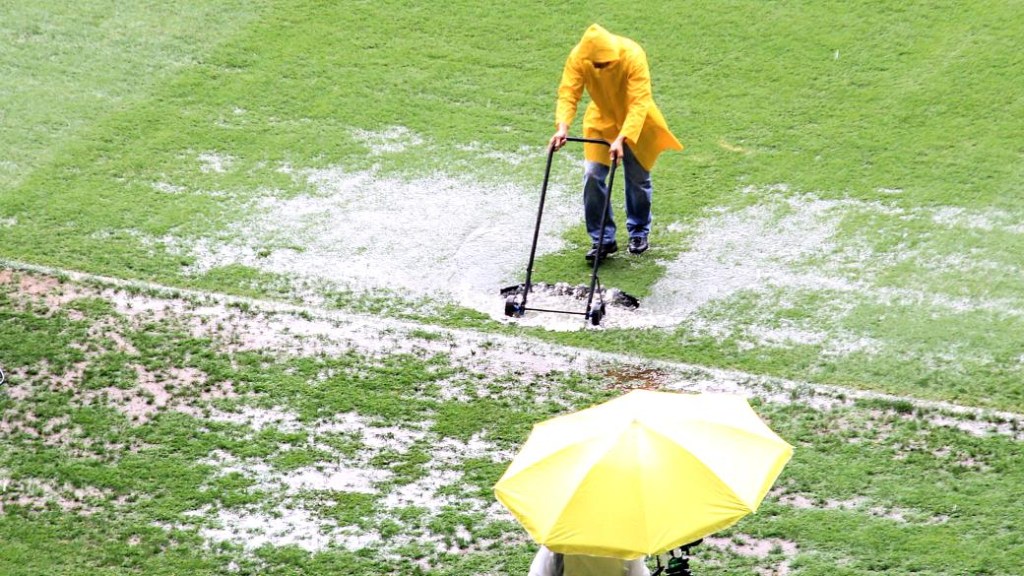 Antes da partida contra o Goiás, funcionários do Mineirão tiveram trabalho para retirar o excesso de água no gramado