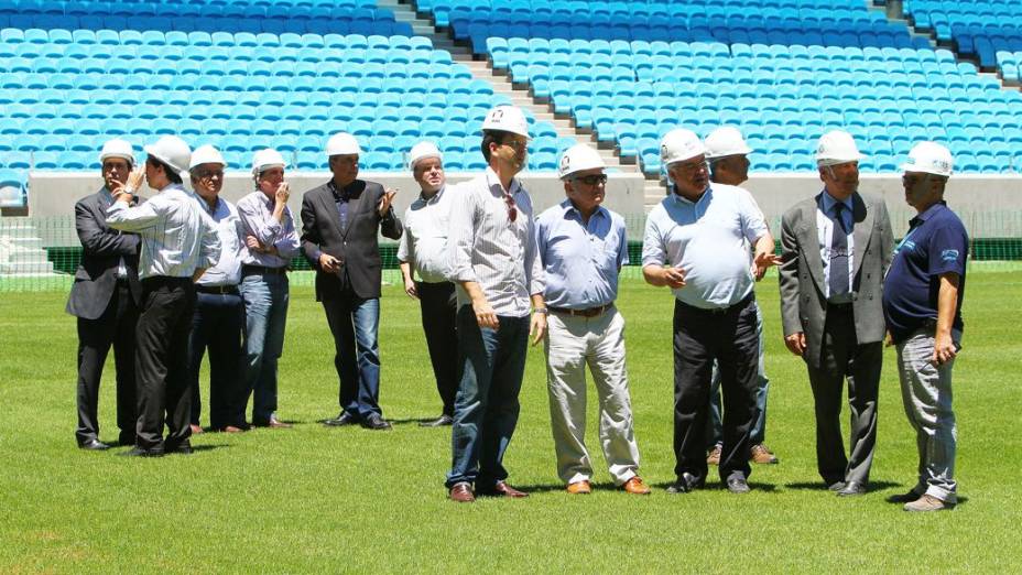 O presidente do Grêmio, Paulo Odone, leva o presidente eleito do clube, Fábio Koff, ao campo da nova arena