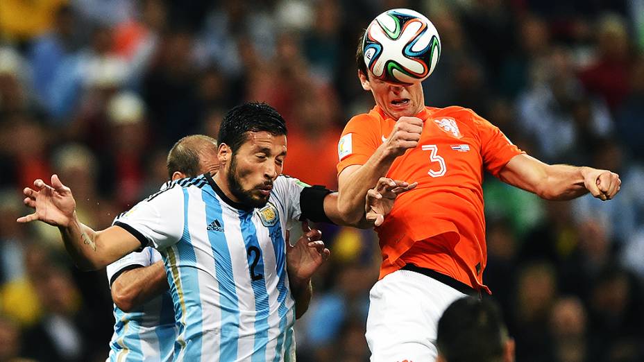 Jogadores disputam a bola de cabeça no jogo entre Holanda e Argentina no Itaquerão, em São Paulo