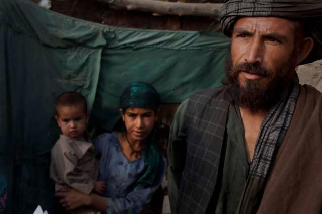 Habitantes afegãos esperam para serem revistado por soldados americanos na vila de Kuhak