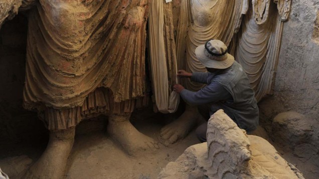 Arqueólogo examina restos de estátuas encontrados em um antigo monastério em Mes Aynak, no Afeganistão