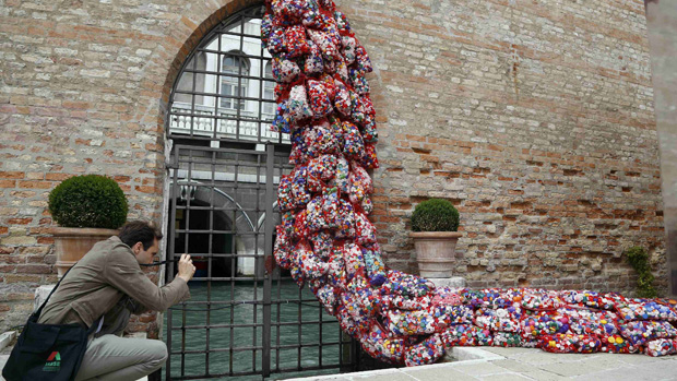 Visitante fotografa a instalação The Garbage Patch State da italiana Maria Cristina Finucci, na Bienal de Veneza