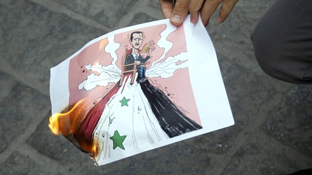 Sírio queima cartoon com imagem do presidente Assad