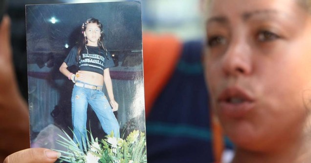 Mulher em frente a um hospital no Rio de Janeiro mostra foto da jovem Larissa dos Santos Atanázio, uma das vítimas da tragédia na Escola Municipal Tasso da Silveira, no bairro Realengo, Rio de Janeiro