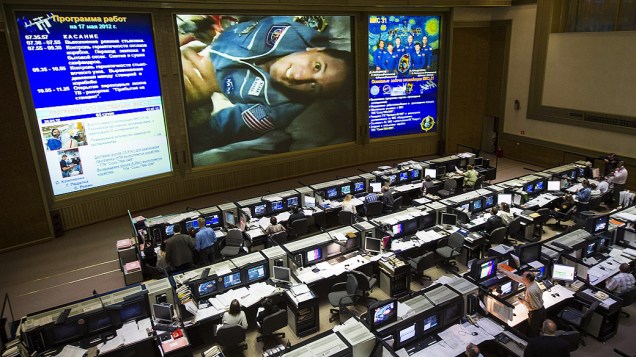 Astronauta aparece no telão do centro de controle espacial, na Rússia, após acoplagem da Soyuz na Estação Espacial