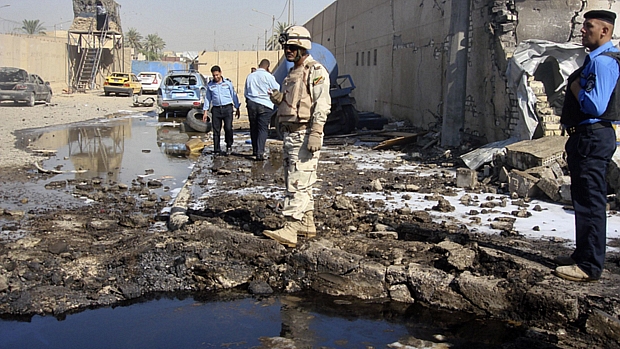 Policial monitora posto policial atacado neta quarta-feira em Bagdá: ao menos 14 pessoas morreram na onda de atentados
