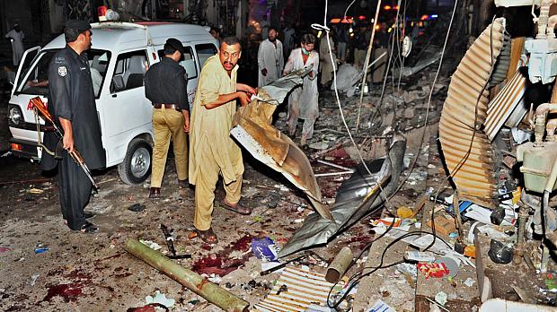 Paquistaneses recolhem os escombros de supermercado onde duas bombas explodiram neste sábado