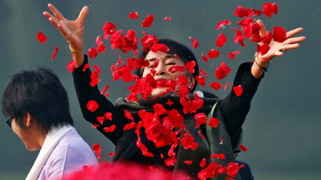 A líder oposicionista de Mianmar, Aung San Suu Kyi, dispersa pétalas de rosas no memorial do primeiro premiê indiano, Jawaharlal Nehru, em Nova Délhi