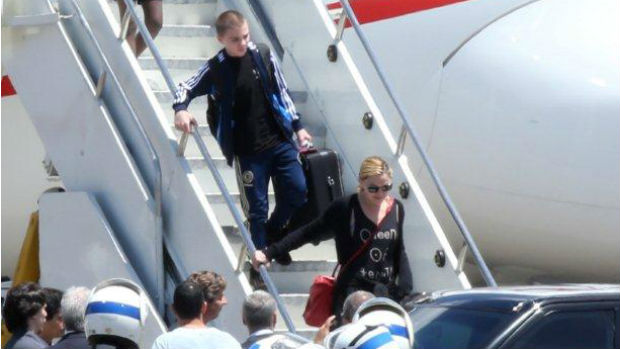 Madonna e o filho Rocco descem do avião, carregando as próprias malas