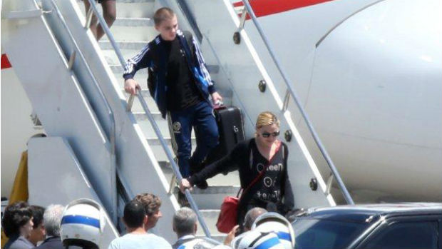 Madonna e o filho Rocco descem do avião, carregando as próprias malas Madonna e o filho Rocco descem do avião, carregando as próprias malas