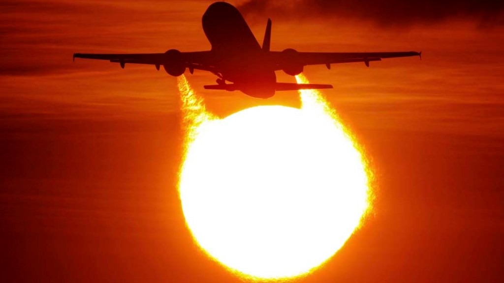Avião decola durante o pôr do sol no aeroporto de Duesseldorf na Alemanha