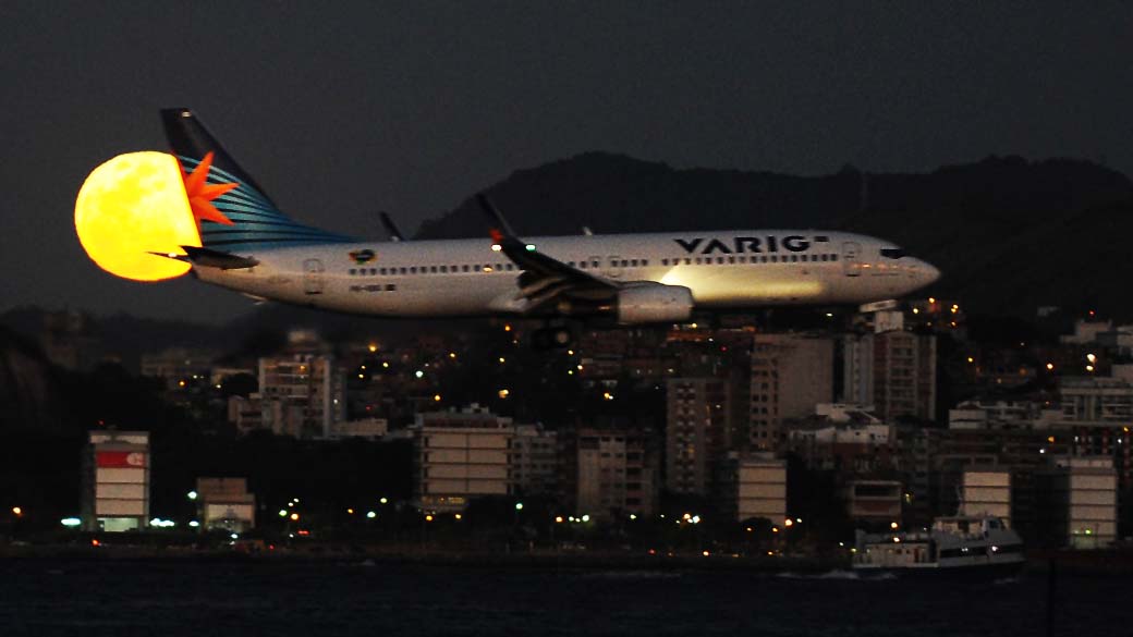 Avião da Varig pousa no aeroporto Santos Dumont com a lua cheia ao fundo no Rio de Janeiro