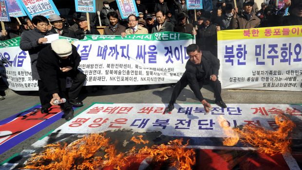 Manifestantes põem fogo na bandeira norte coreana em Seoul, capital da Coreia do Sul