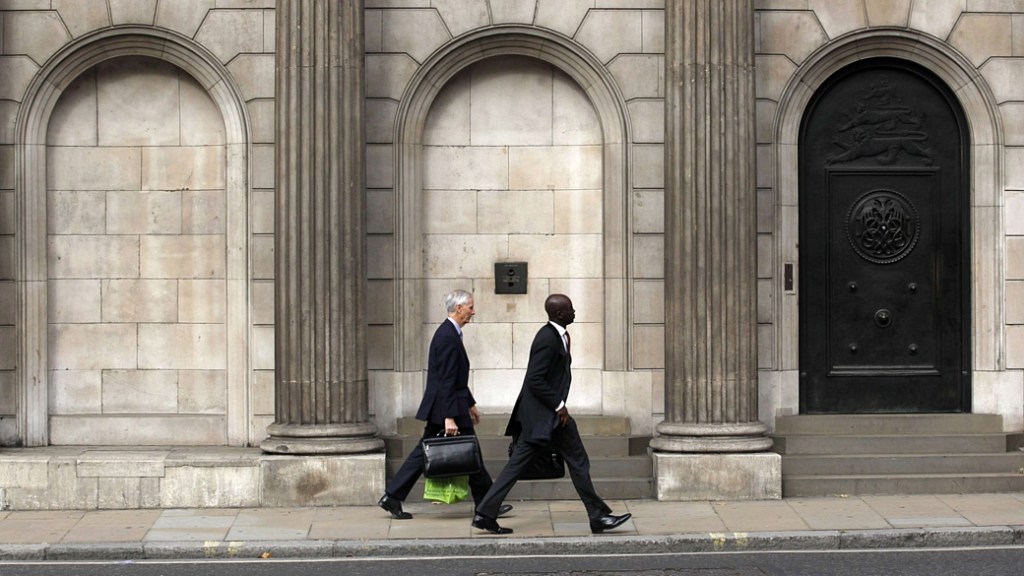 Homens caminham em frente à sede do Banco da Inglaterra (BoE), em Londres