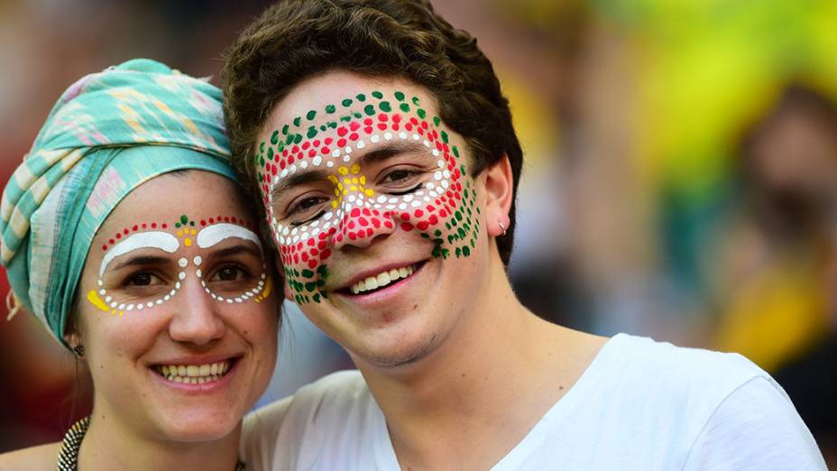 Torcedores pintam o rosto com as cores da bandeira de Gana