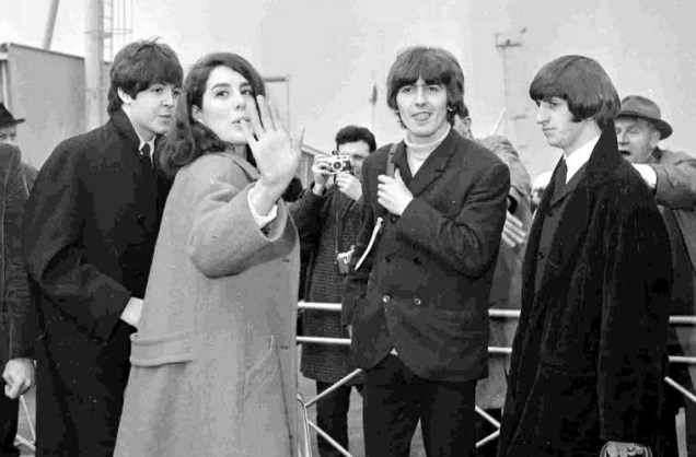 A atriz britânica Eleanor Bron ao lado de Paul McCartney, George Harrison e Ringo Starr, no aeroporto de Londres, em 1965. Estavam prestes a embarcar para as Bahamas.